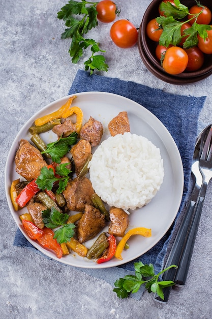 Frango com legumes com arroz no prato no fundo da mesa de pedra cinza. Comida Tailandesa Azia