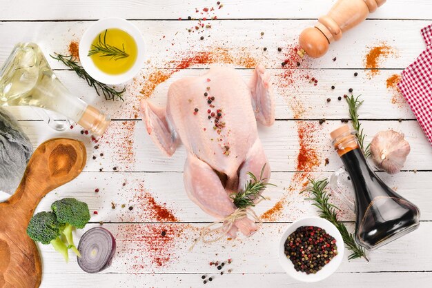 Foto frango cru com legumes e especiarias churrasco em um fundo branco de madeira vista superior espaço para cópia grátis