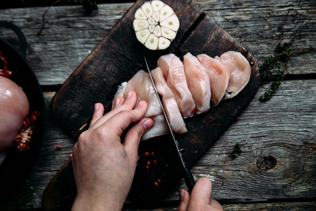 Frango cru em uma mesa de madeira com especiarias