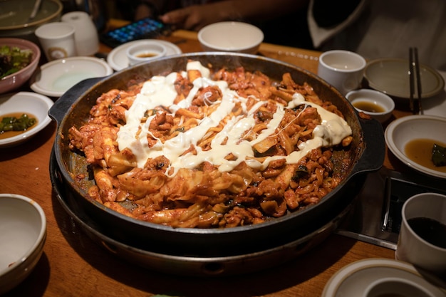 Frango de churrasco Dakgalbi com legumes e queijo misturados em panela quente