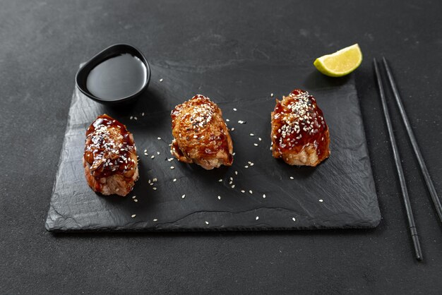 Frango de cozinha chinesa de aperitivo asiático em molho agridoce em um frango de fundo preto com t