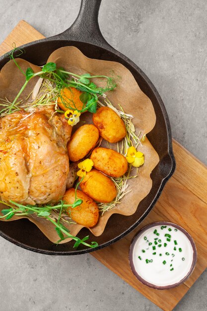 Frango de tabaco cozido com batatas, creme de leite, ervas na panela