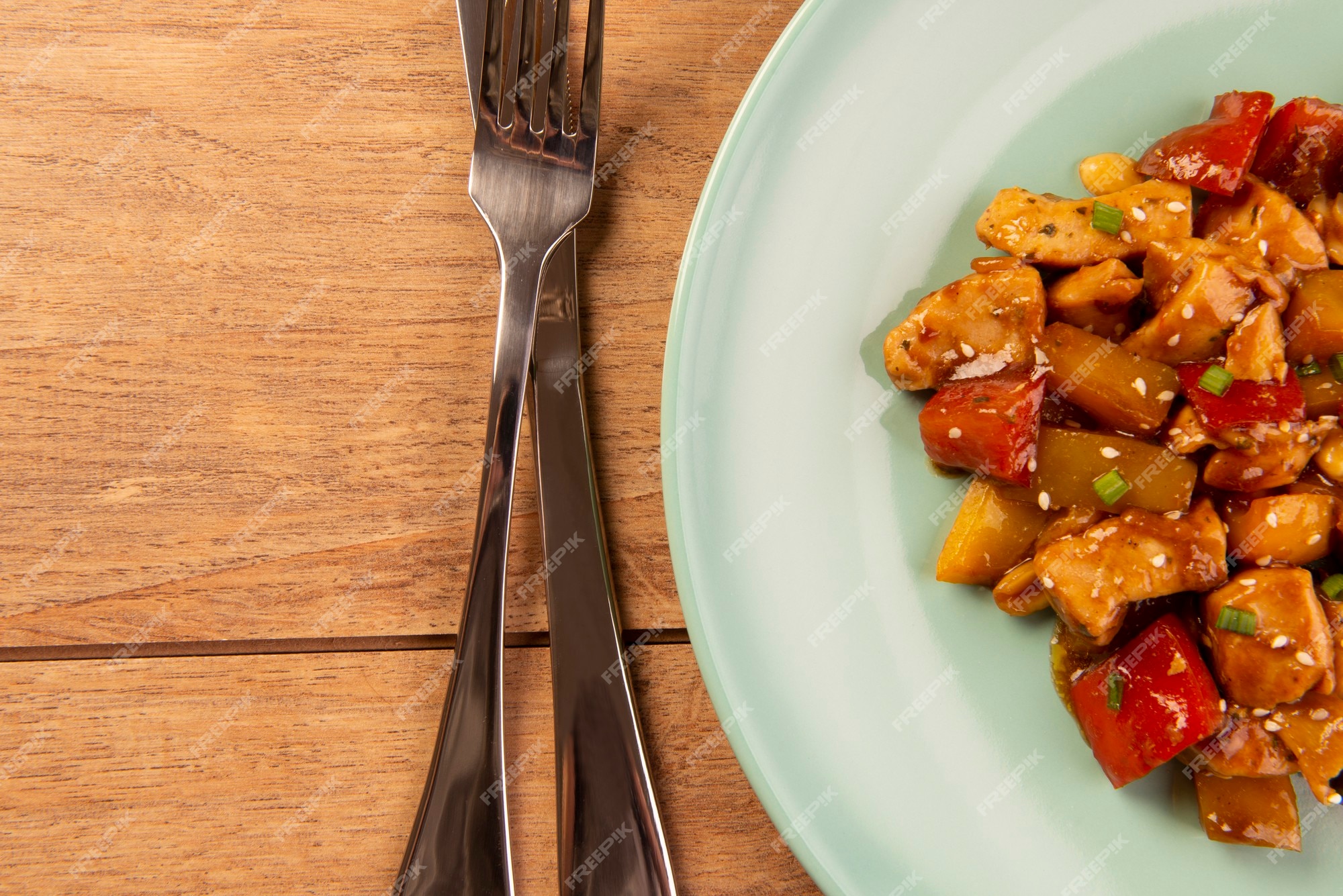 Frango de xadrez em prato verde sobre fundo de madeira - comida chinesa.