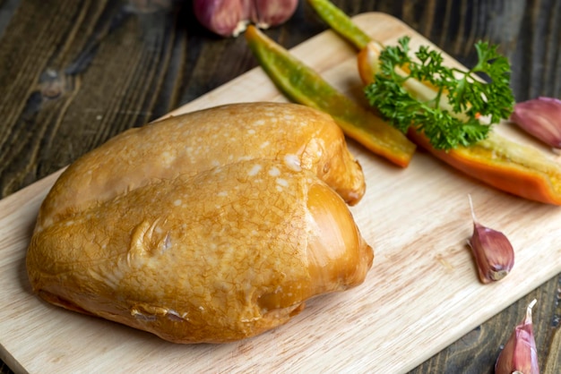 Frango defumado é cortado em uma tábua cozinhando um prato de carne usando peito de frango defumado