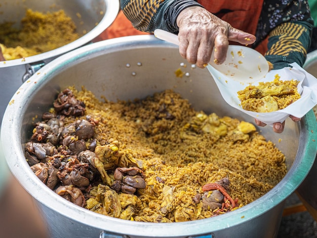 Frango em arroz amarelo em panela para venda no mercado local da manhã na Tailândia Menu muçulmano famoso