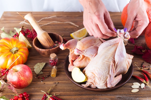 Frango em um prato com maçã de especiarias e laranja em uma mesa de madeira.