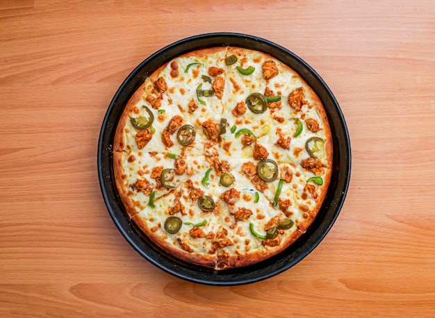 Frango Fajita Pizza isolado em cubos de frango temperados com fundo de madeira e combinação de queijo no pão Vista superior de comida italiana