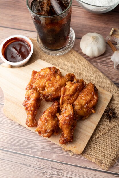 Frango frito churrasco quente e picante coreano na tábua de madeira