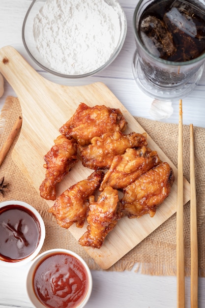 Frango frito churrasco quente e picante coreano na tábua de madeira