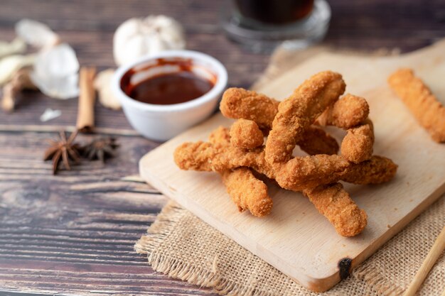 Frango frito churrasco quente e picante coreano na tábua de madeira