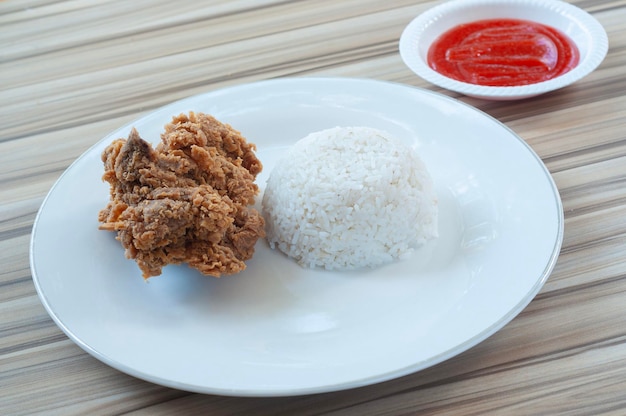 Frango frito com arroz branco e vegetais como guarnição