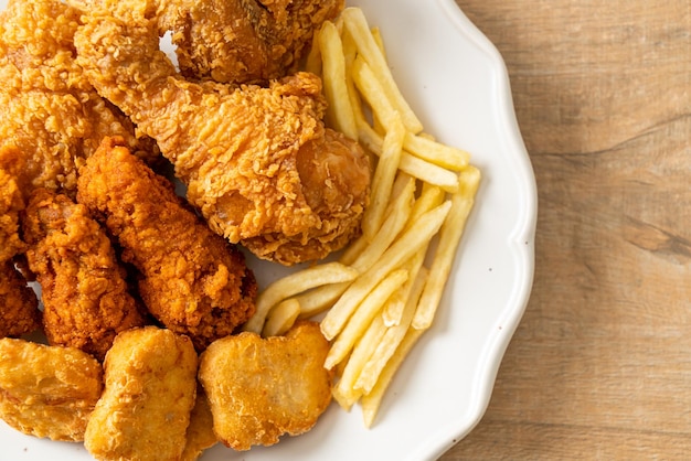 Frango frito com batatas fritas e nuggets no prato