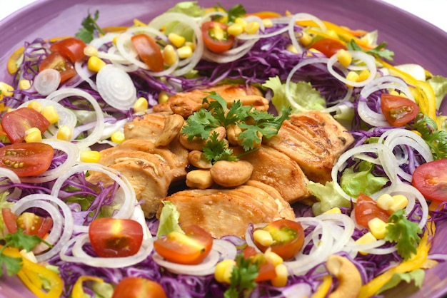 Frango frito com verduras e legumes closeup na placa roxa