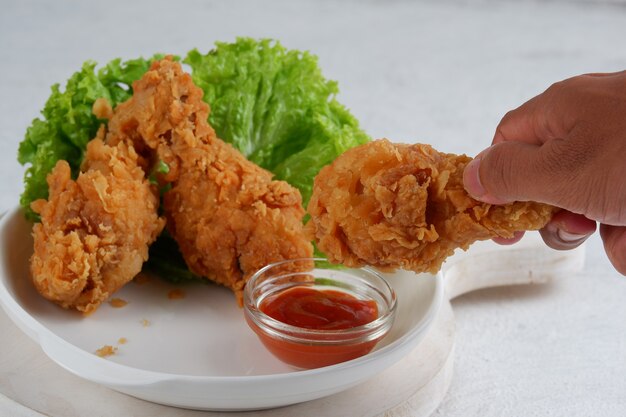 frango frito crocante com molho de pimenta no fundo branco