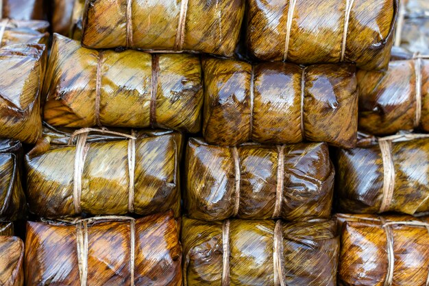 Frango frito envolto em folhas verdes de pandan em mercado de comida de rua na Tailândia