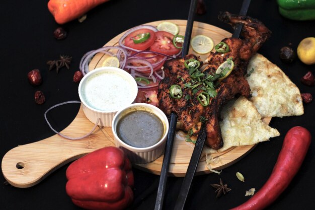 Frango grelhado com legumes com molhos em tábuas de madeira