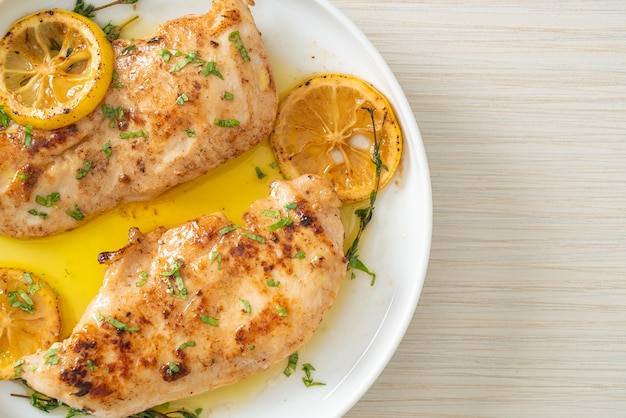 frango grelhado com manteiga, limão e alho no prato branco