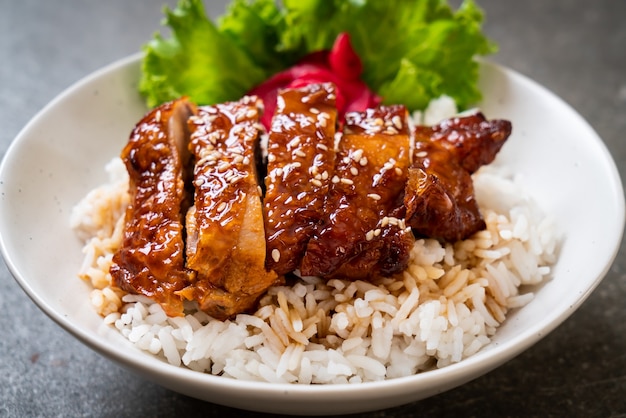 Frango grelhado com molho teriyaki na tigela de arroz com cobertura