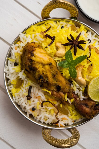 Frango Hyderabadi ou dum biryani, servido em um Kadhai ou tigela com molho de iogurte. foco seletivo