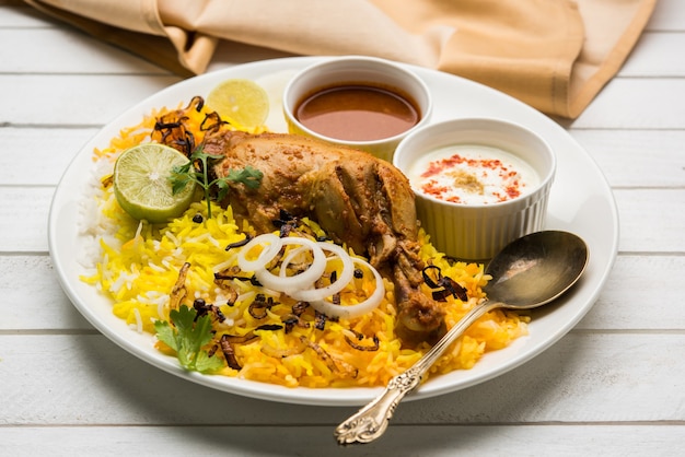 Frango Hyderabadi ou dum biryani, servido em um Kadhai ou tigela com molho de iogurte. foco seletivo