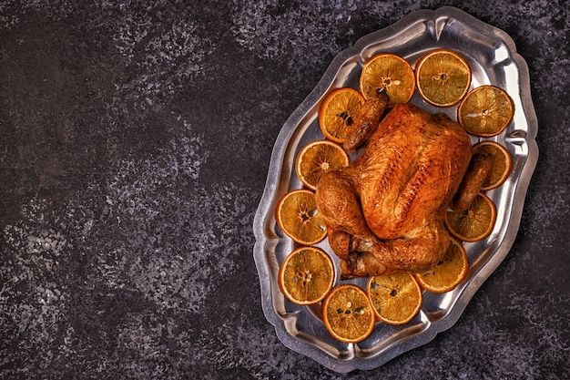 Frango inteiro assado com laranja em uma bandeja