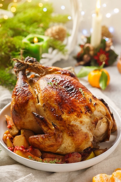 Foto frango inteiro assado com tangerinas e maçãs