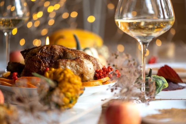 Foto frango inteiro assado ou peru para o natal tábua de ação de graças com decoração frango assado caseiro vinho e salada de frutas fundo bokeh