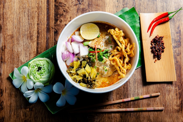 Frango Khao Soi, um alimento tailandês muito popular no norte, junto com os acompanhamentos.