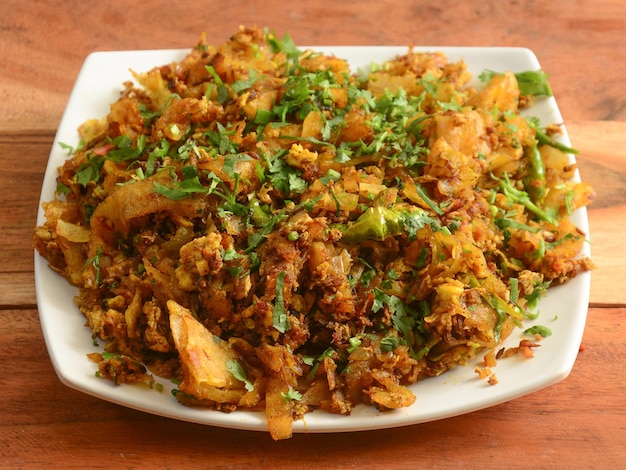 Frango Kothu Parotta ou pão sírio indiano desfiado ao curry, uma comida de rua popular do sul da Índia feita com pedaços de pão em camadas e foco seletivo de ovos e vegetais de carne