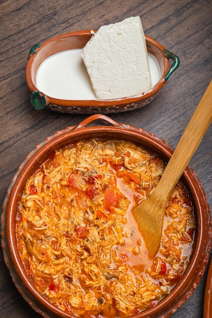 Frango mexicano autêntico tinga comida típica mexicana preparada em uma panela de barro sobre uma mesa de madeira