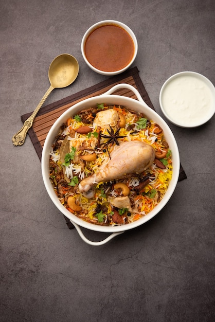 Frango picante Biryani em estilo restaurante servido com Raita e Salan, comida popular indiana ou paquistanesa não vegetariana