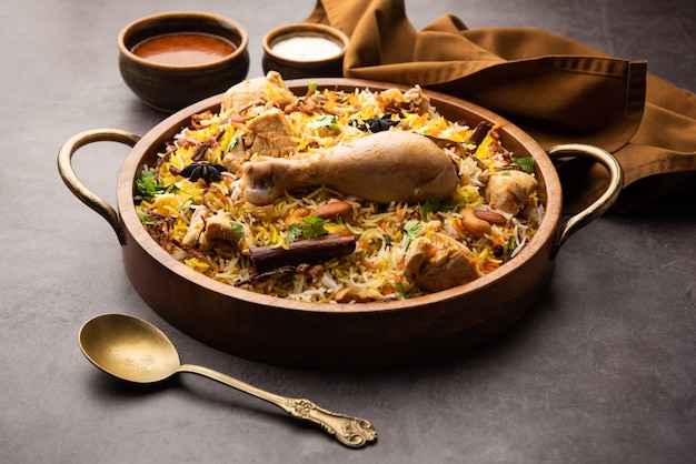 Frango picante biryani em estilo restaurante servido com raita e salan, comida popular indiana ou paquistanesa não vegetariana