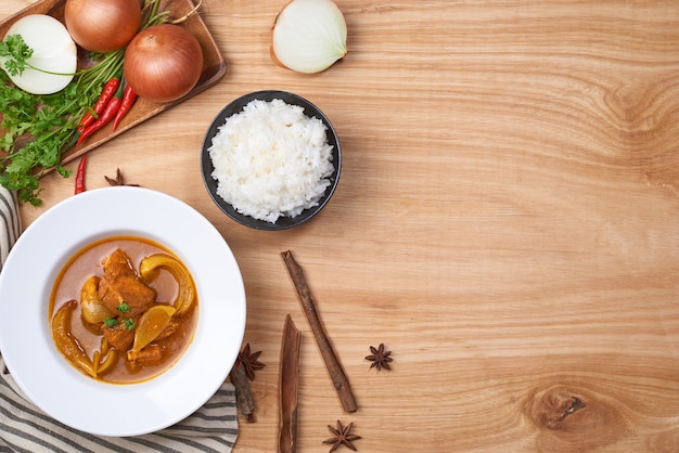 Frango picante e arroz em fundo de madeira