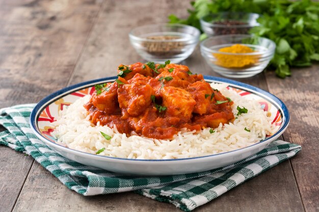 Frango tikka masala com arroz basmati na mesa de madeira