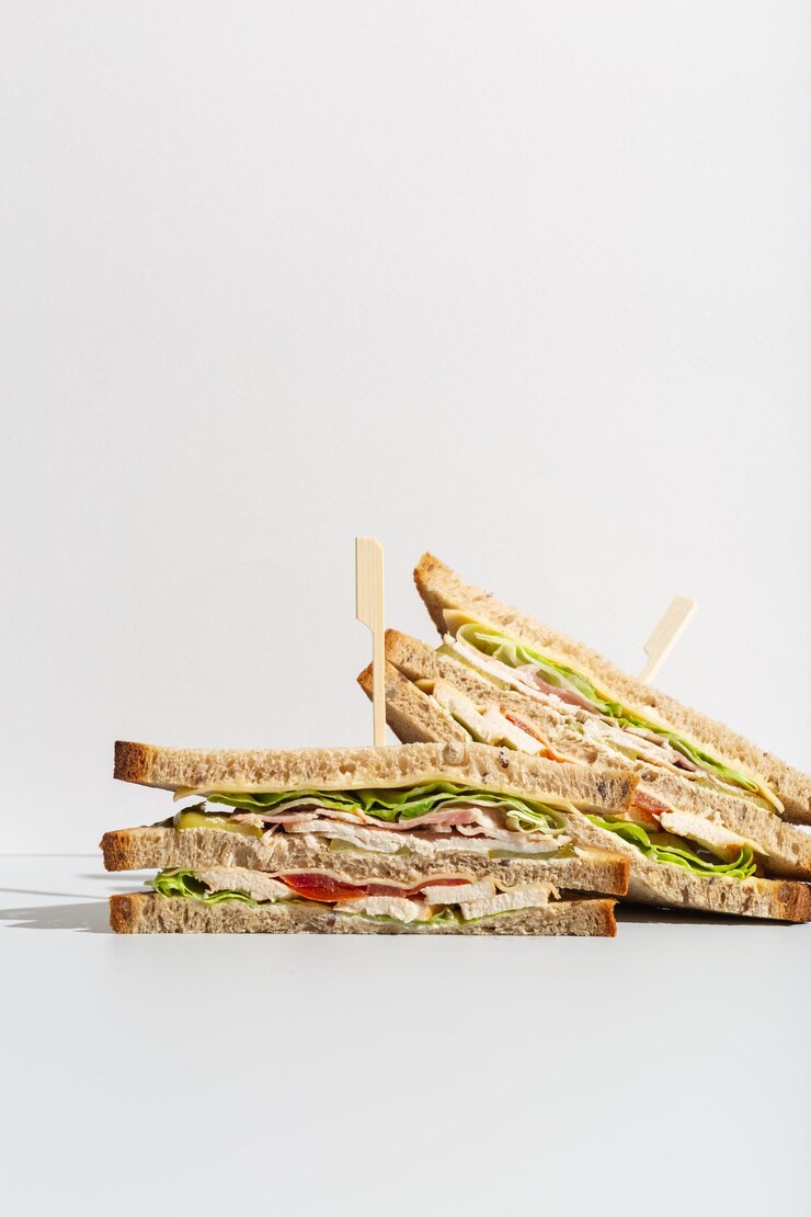 Frango, tomate e salada, pão integral, sanduíche triângulos em minimalismo cinza foto de alta qualidade