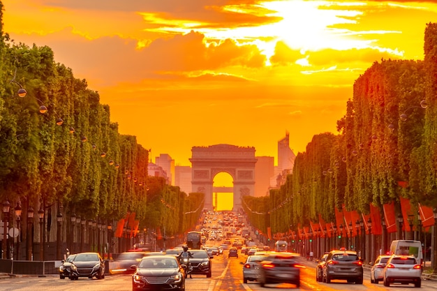 Frankreich. Goldener Sommersonnenuntergang auf den Champs Elysees in Paris. Arc de Triomphe und Autoverkehr