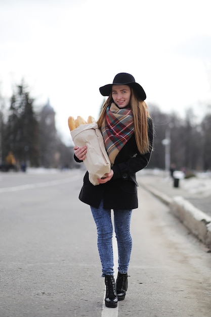 Französin mit Baguettes in der Tüte auf dem Weg aus dem Laden