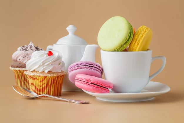 Französische Macarons in der Tasse auf weißem Teller