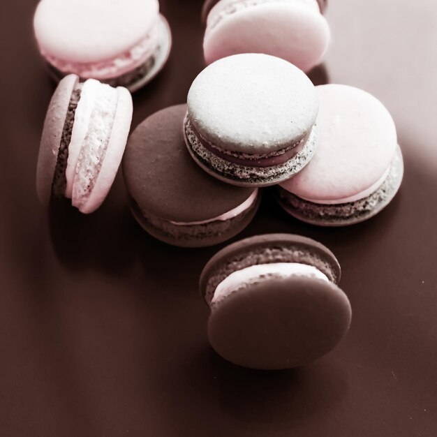 Französische Makronen auf Milchschokoladenhintergrund Pariser schickes Café-Dessert süßes Essen und Kuchen-Macaron für Luxus-Süßwarenmarken-Urlaubshintergrund-Design