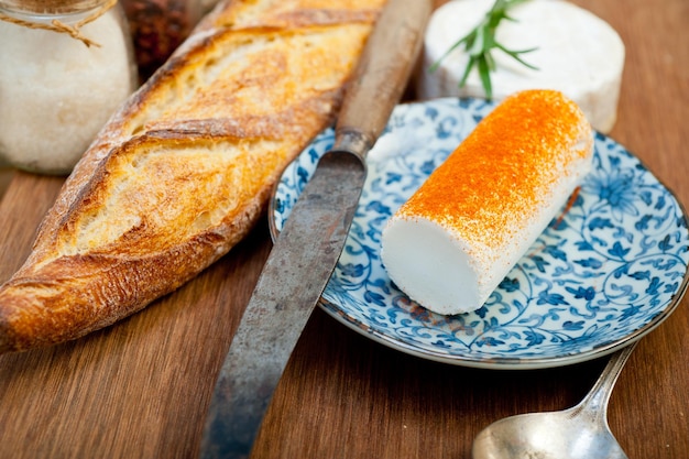 Französischer Käse und frisches Baguette auf einem Holzschneider