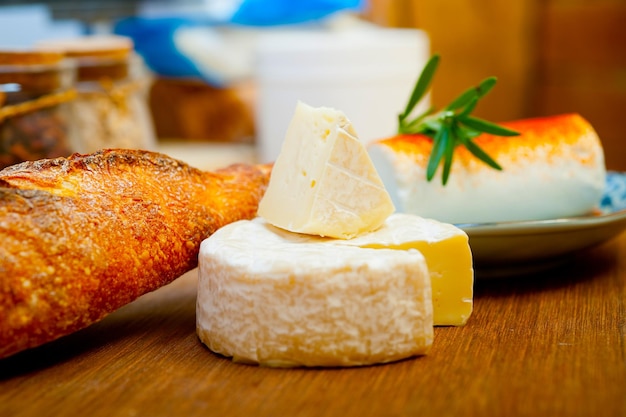 Foto französischer käse und frisches baguette auf einem holzschneider