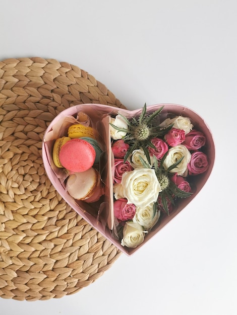 Französischer Macaron-Kuchen mit Rosen in einer herzförmigen Schachtel Süßes Geschenk