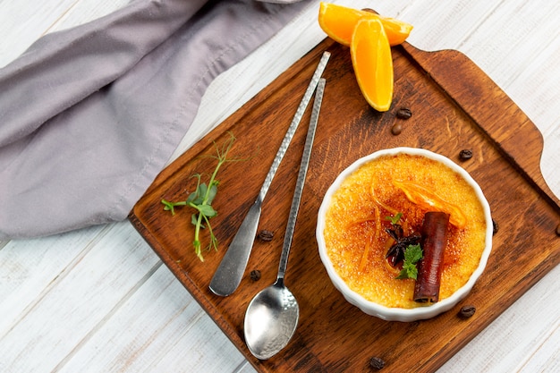 Französischer Vanille Creme brulee Nachtisch in der keramischen Schüssel auf hölzernem Brett, Draufsicht