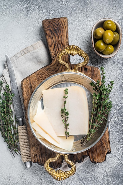 Französischer Ziegenhartkäse in einer Pfanne mit Kräutern Weißer Hintergrund Ansicht von oben