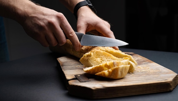 Foto französisches baguette für bruschettas, geschnitten mit messer auf holzbrett von frauenhänden rustikales, knuspriges müsli b