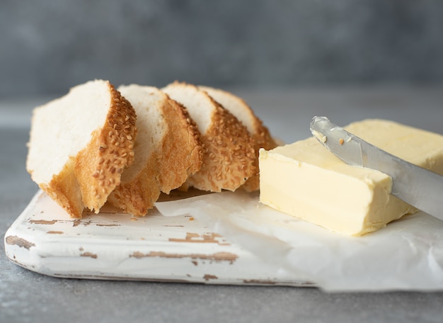 Französisches Baguette mit Butter auf einem Holzbrett