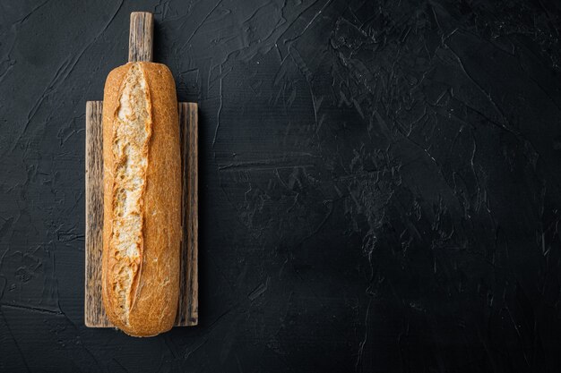 Foto französisches baguettebrot gebacken, auf schwarzem hintergrund, draufsicht flach mit kopienraum für text