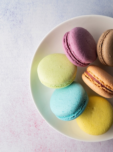 Französisches Dessert bunte Makronen auf dem Teller, minimales Konzept flach