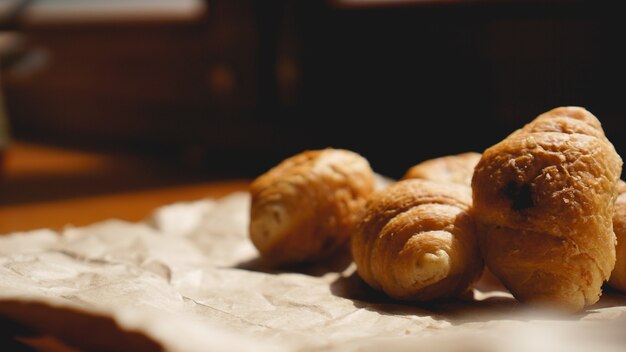 Französisches Frühstück mit Croissant, Kraftgeschirr auf Kraftpapier. Mini-Croissants