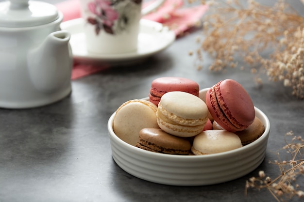 Foto französisches macaron backt in einem plattenabschluß oben zusammen. creme, braun, rosa, macarons.